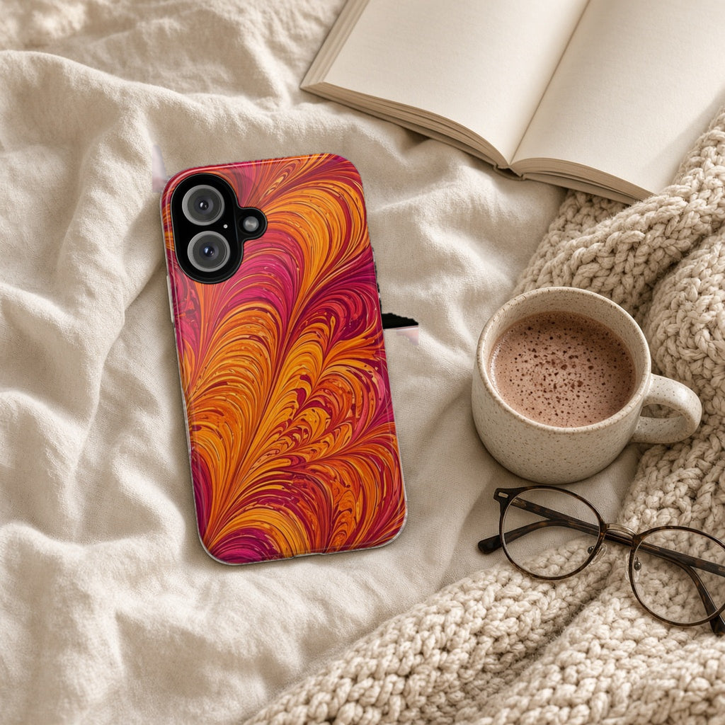 Sunset Feather Marbling tough phone case on a cosy knit blanket with a hot chocolate and glasses