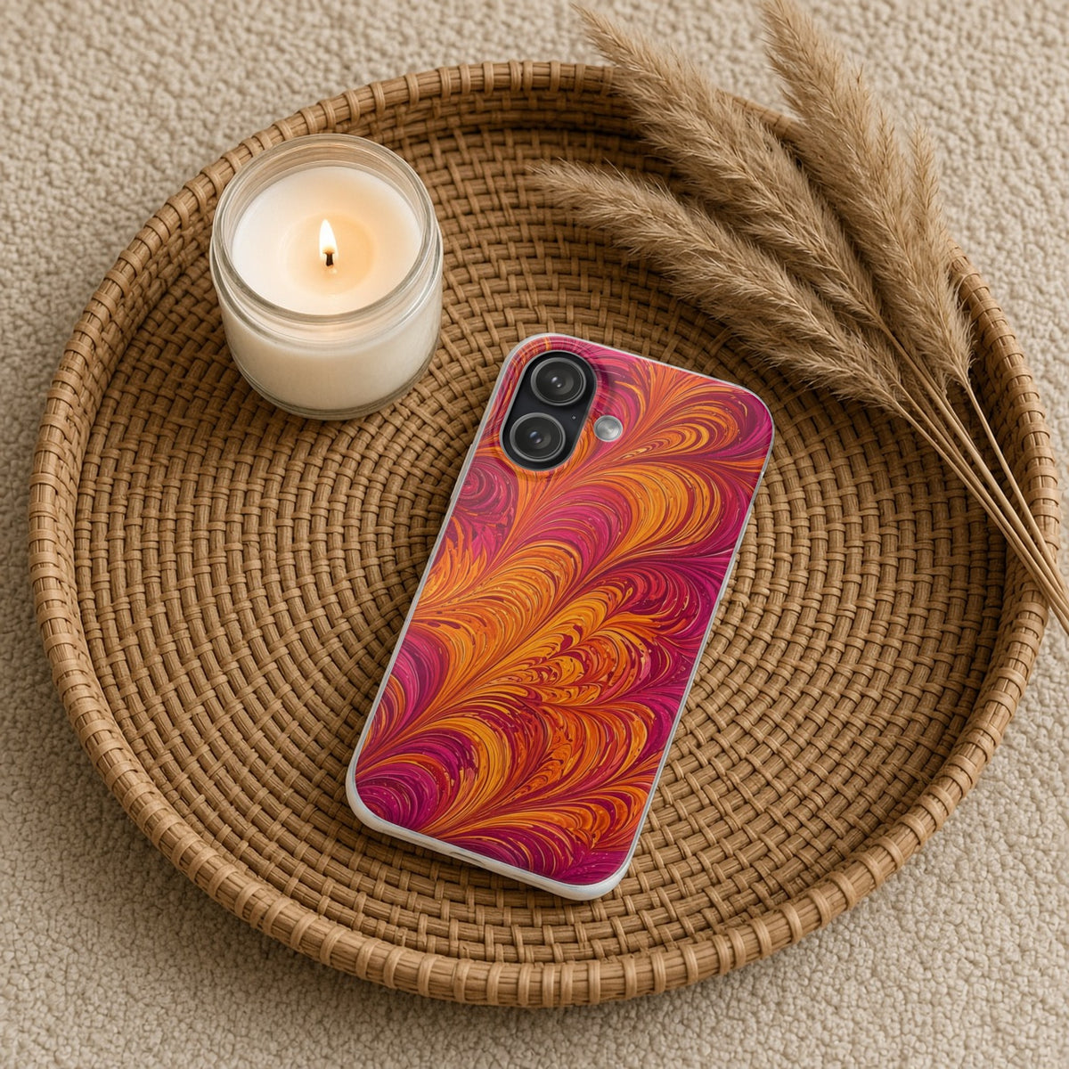 Sunset Feather Marbling flexi phone case on a rattan tray with a candle and dried grasses