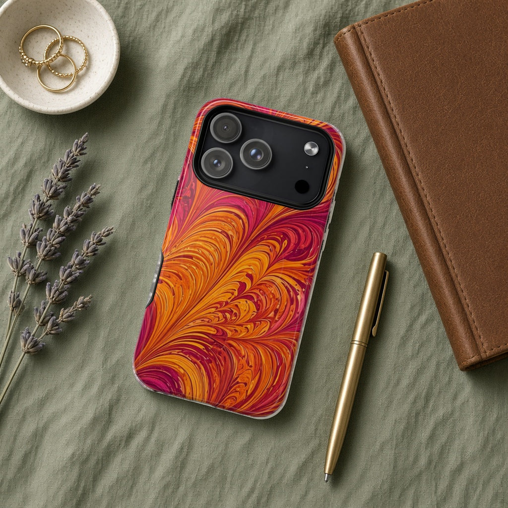 Sunset Feather Marbling magnetic iPhone case flat lay on sage linen with a notebook and pen