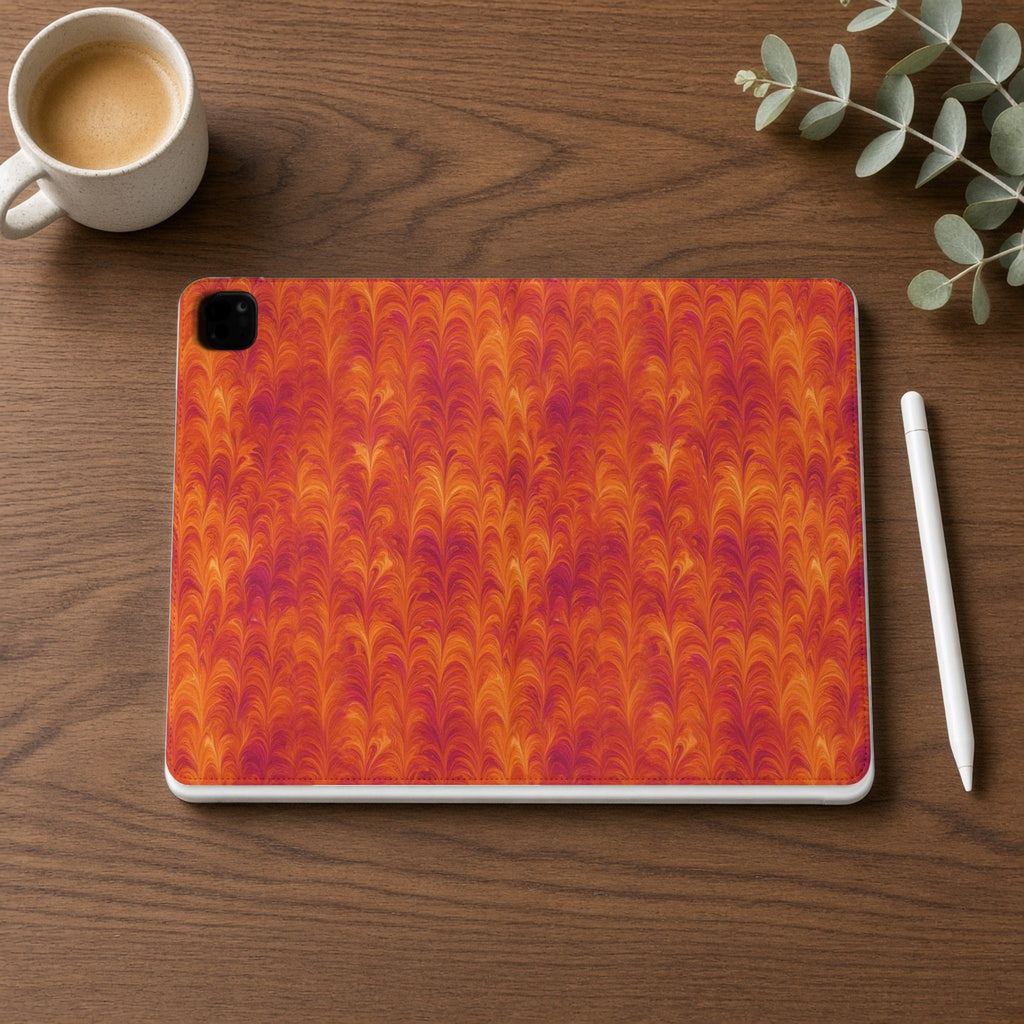 Sunset Feather Marbling iPad folio case on a walnut desk with a stylus and coffee