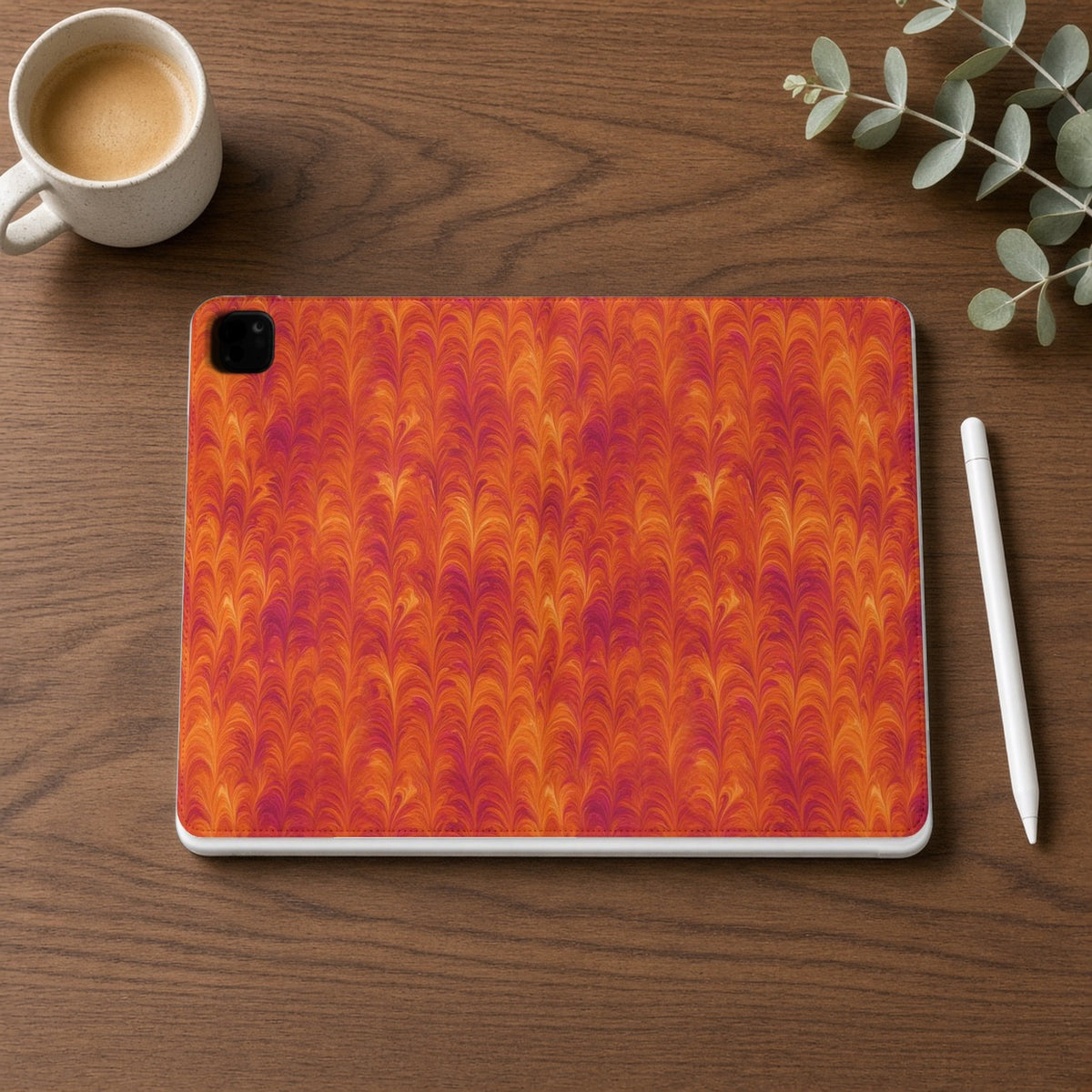 Sunset Feather Marbling iPad folio case on a walnut desk with a stylus and coffee