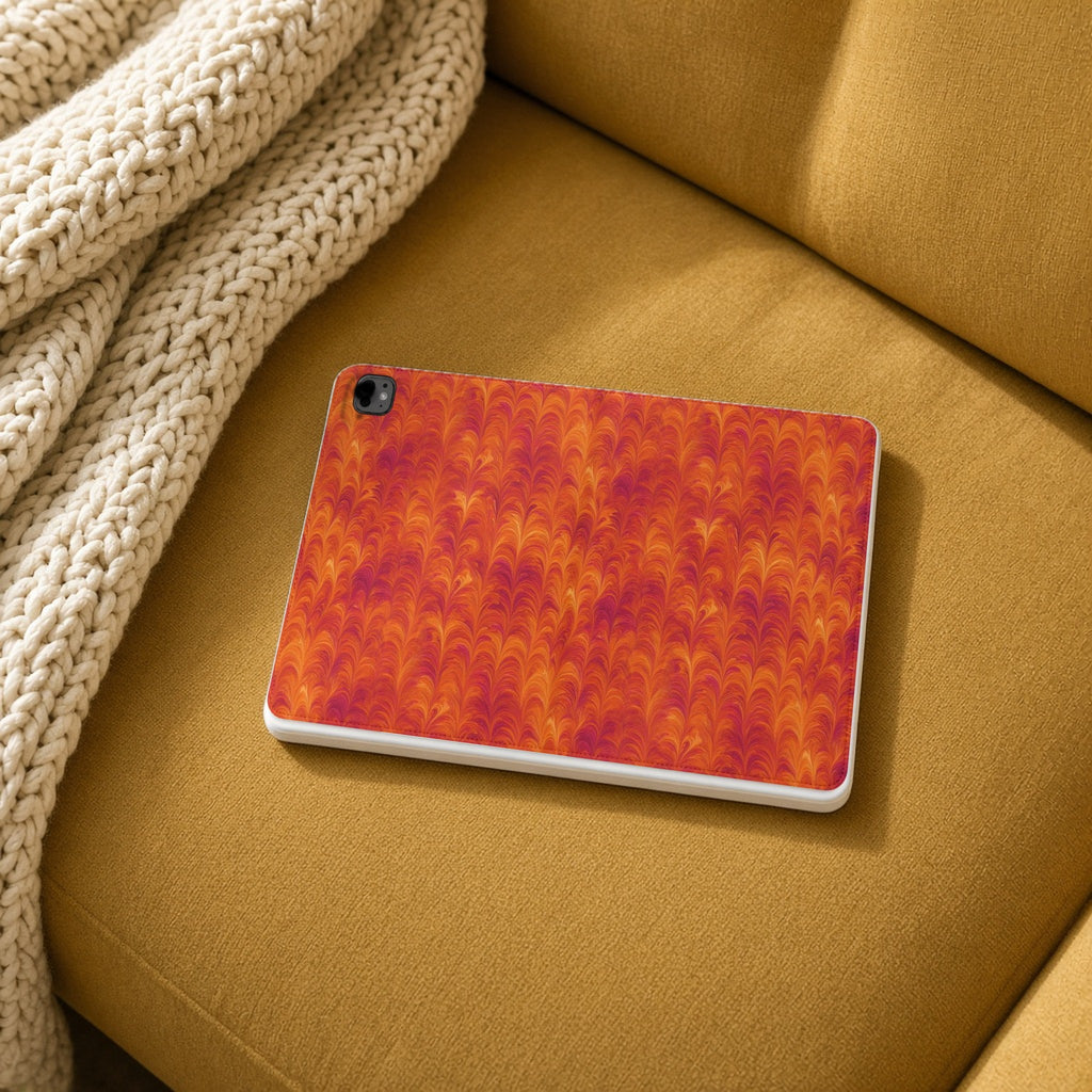 Sunset Feather Marbling iPad folio case on a mustard sofa with a knit throw