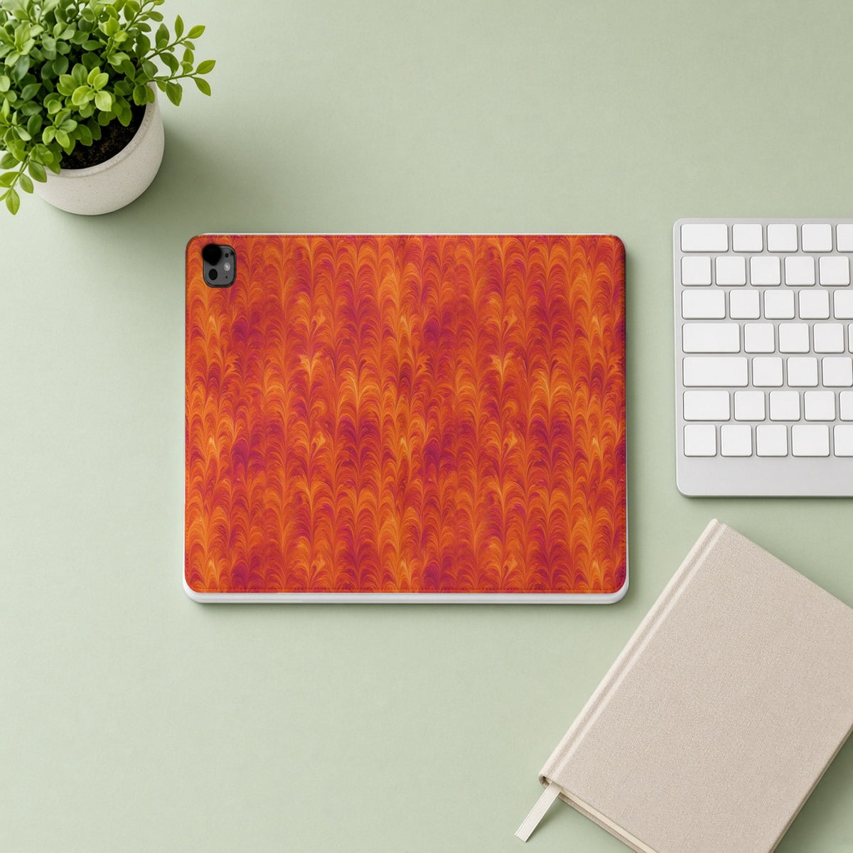 Sunset Feather Marbling iPad folio case from above on a sage desk with a keyboard and notebook