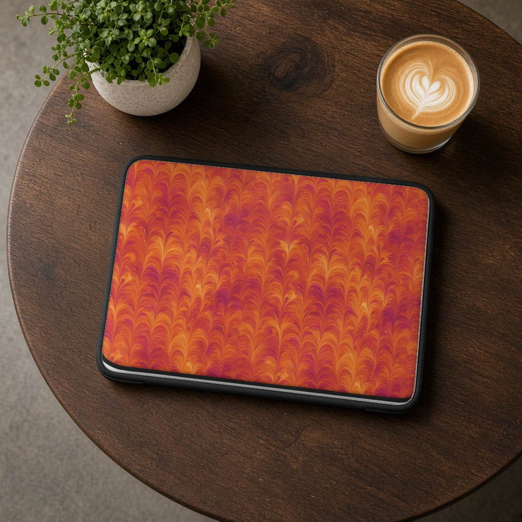 Sunset Feather Marbling laptop sleeve on a round wooden cafe table with a latte