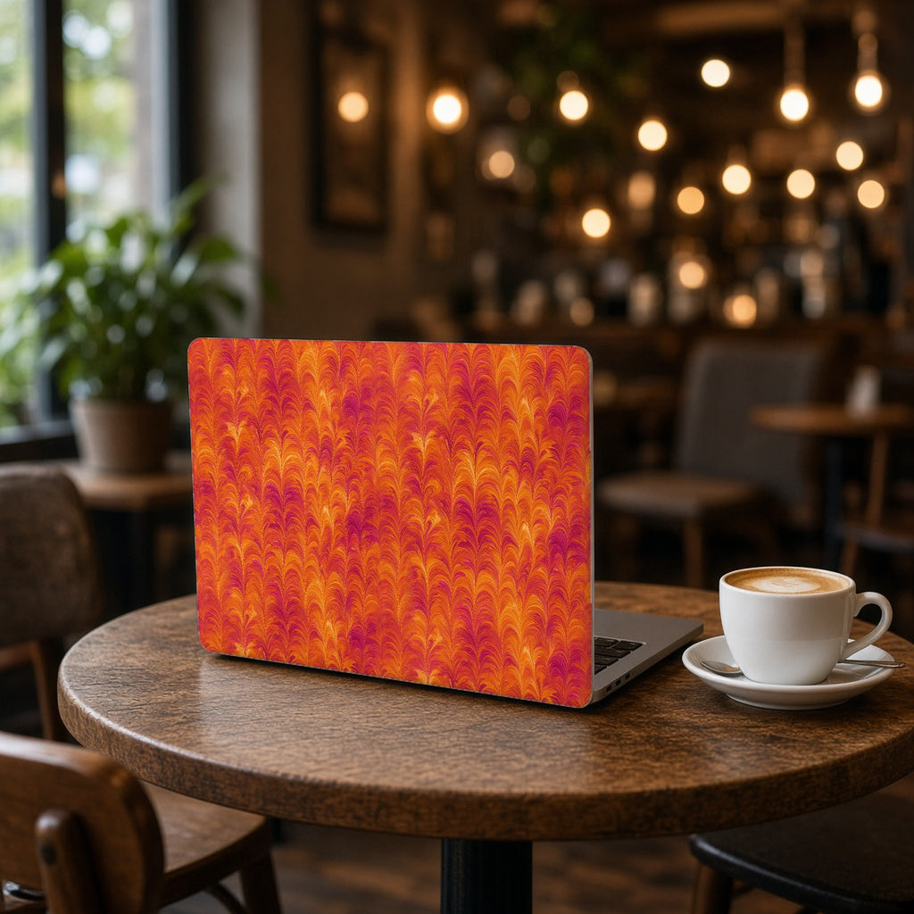 Sunset Feather Marbling matte MacBook case on an open laptop on a cafe table