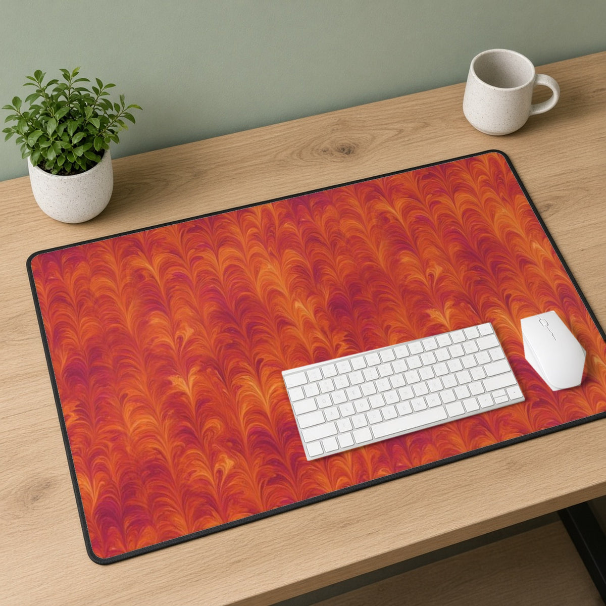 Sunset Feather Marbling desk mat on a sage-walled desk with a white keyboard and mouse
