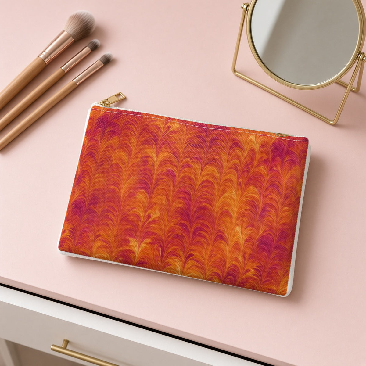 Sunset Feather Marbling zip accessory pouch on a pink dressing table with makeup brushes