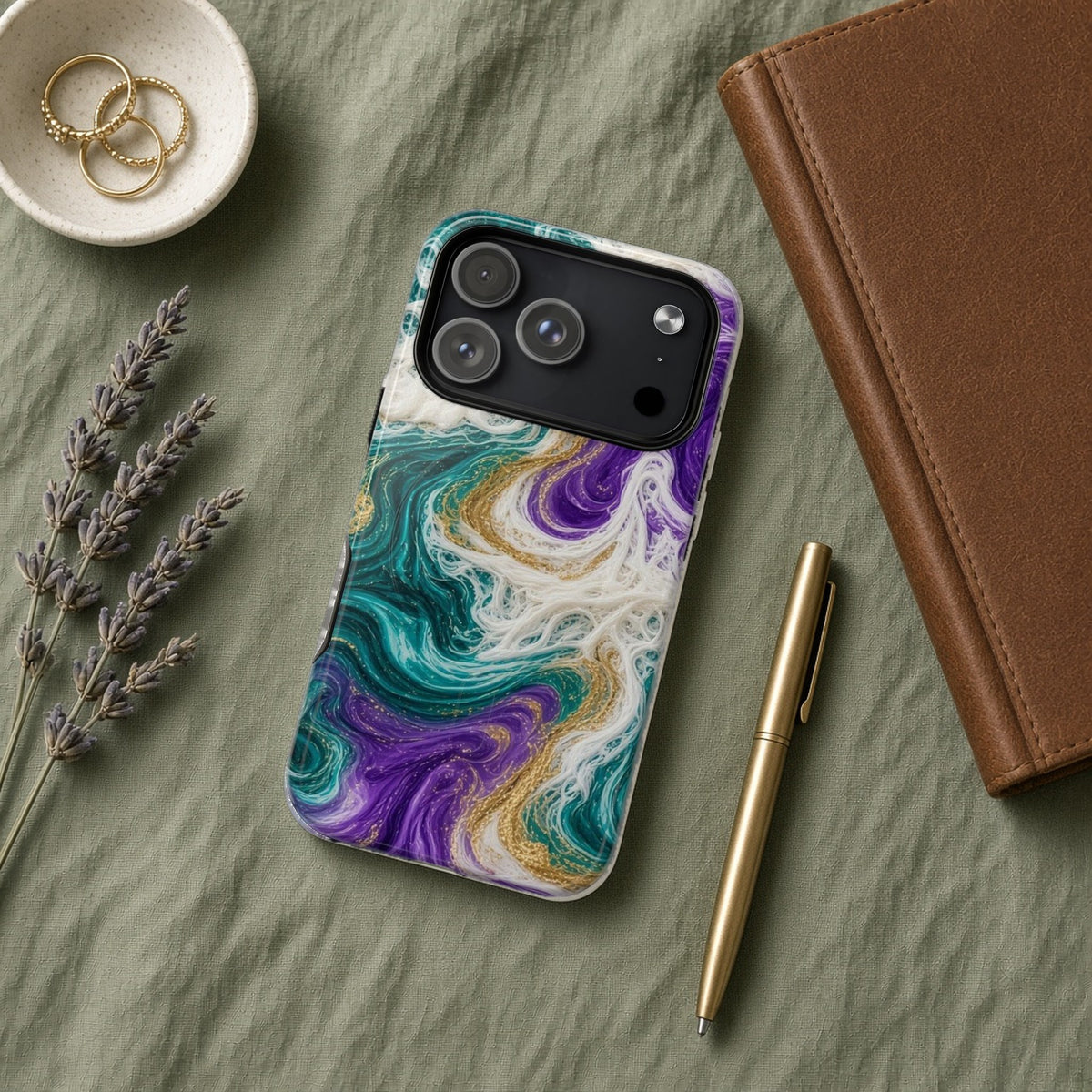 Peacock Resin Wave magnetic iPhone case flat lay on sage linen with a notebook and pen