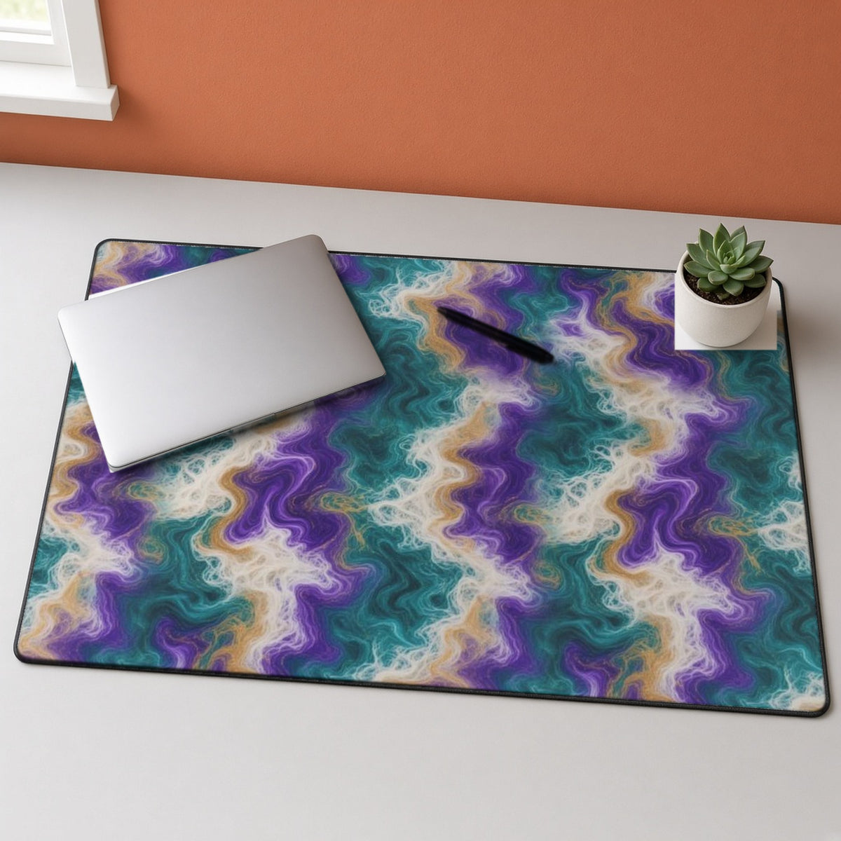 Peacock Resin Wave desk mat on a grey desk with a laptop and a plant
