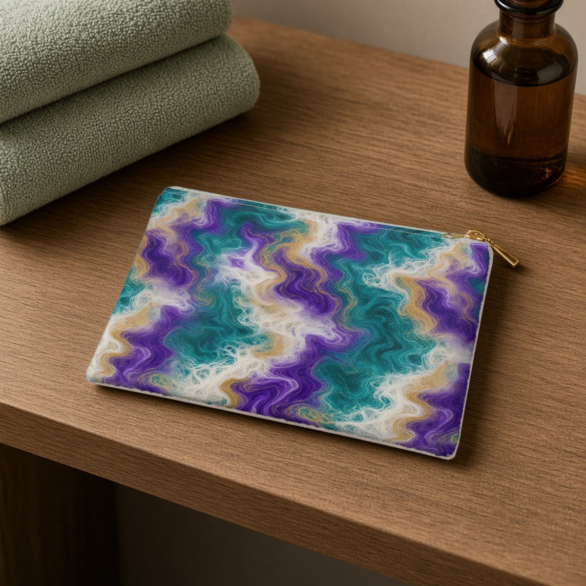 Peacock Resin Wave zip accessory pouch on a wooden shelf with towels and an amber bottle