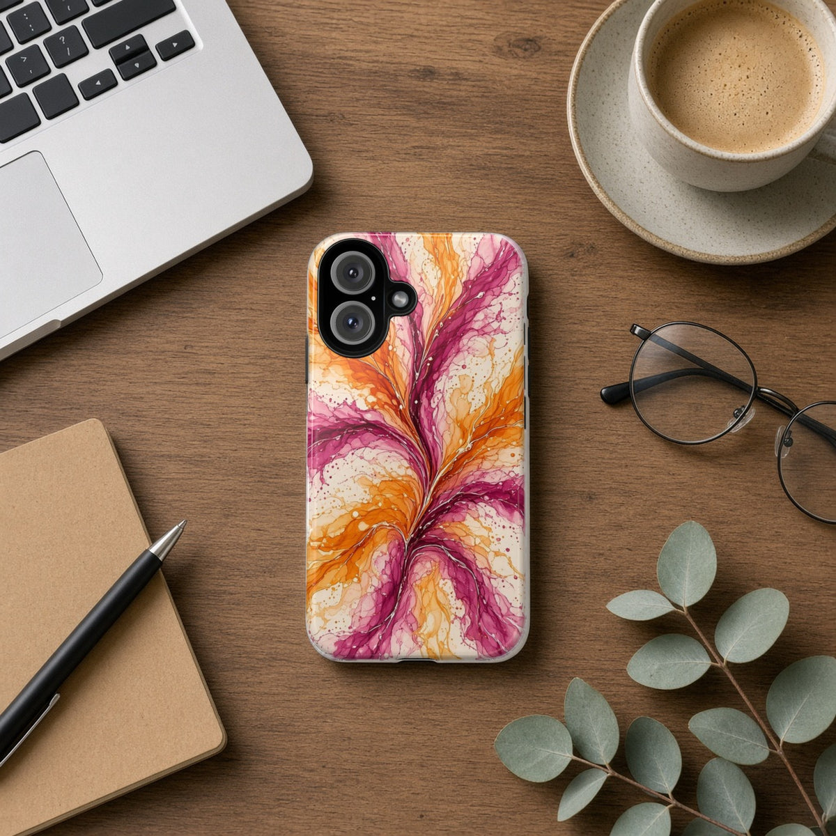 Sunset Ink Branches tough phone case on a wooden desk beside a laptop, coffee and eucalyptus