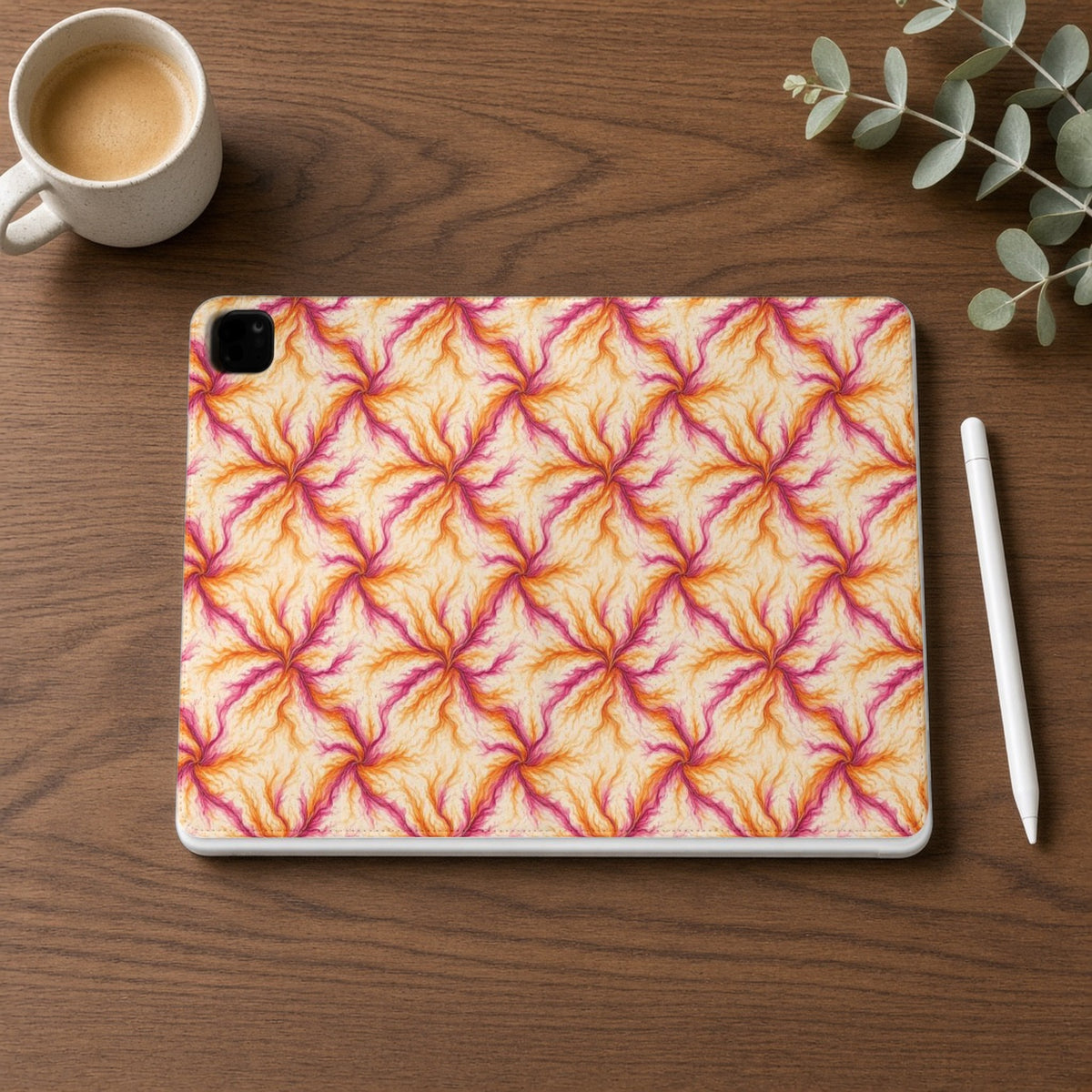 Sunset Ink Branches iPad folio case on a walnut desk with a stylus and coffee