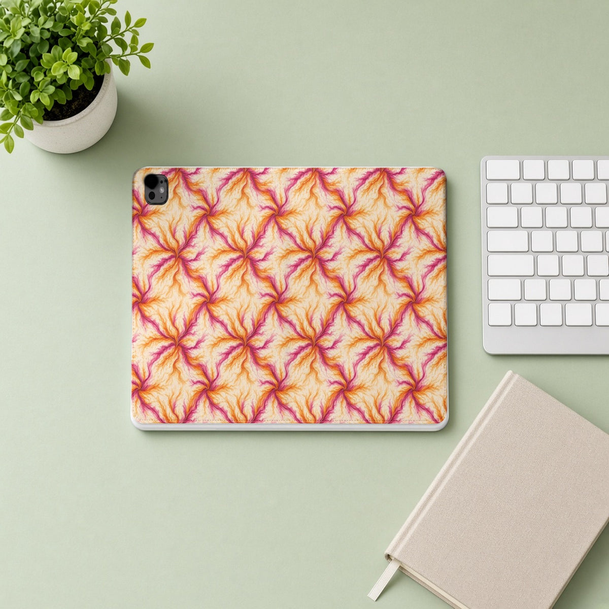 Sunset Ink Branches iPad folio case from above on a sage desk with a keyboard and notebook