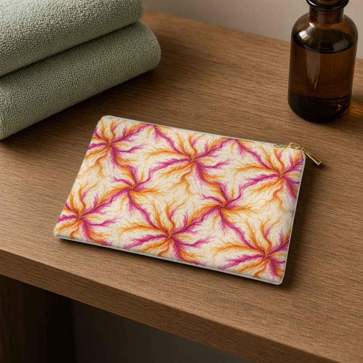 Sunset Ink Branches zip accessory pouch on a wooden shelf with towels and an amber bottle