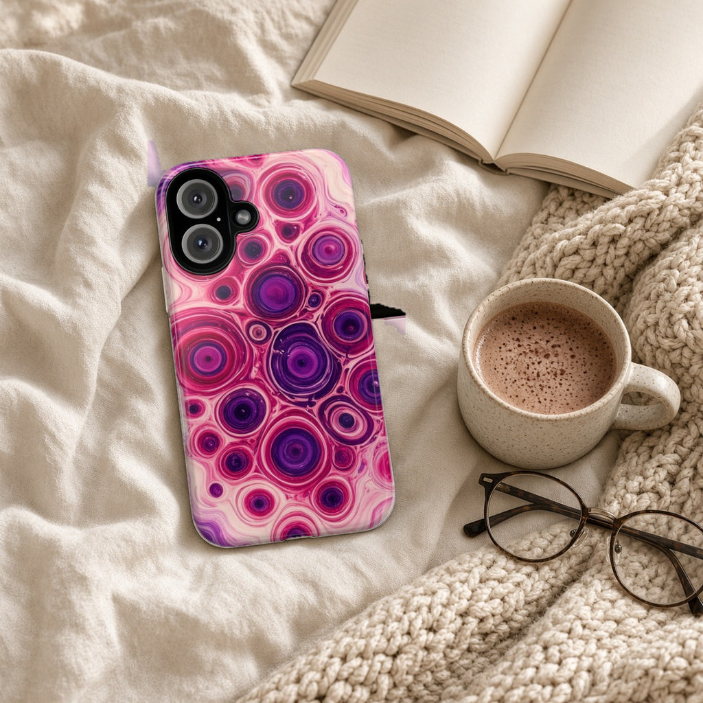 Berry Puddle Pour tough phone case on a cosy knit blanket with a hot chocolate and glasses