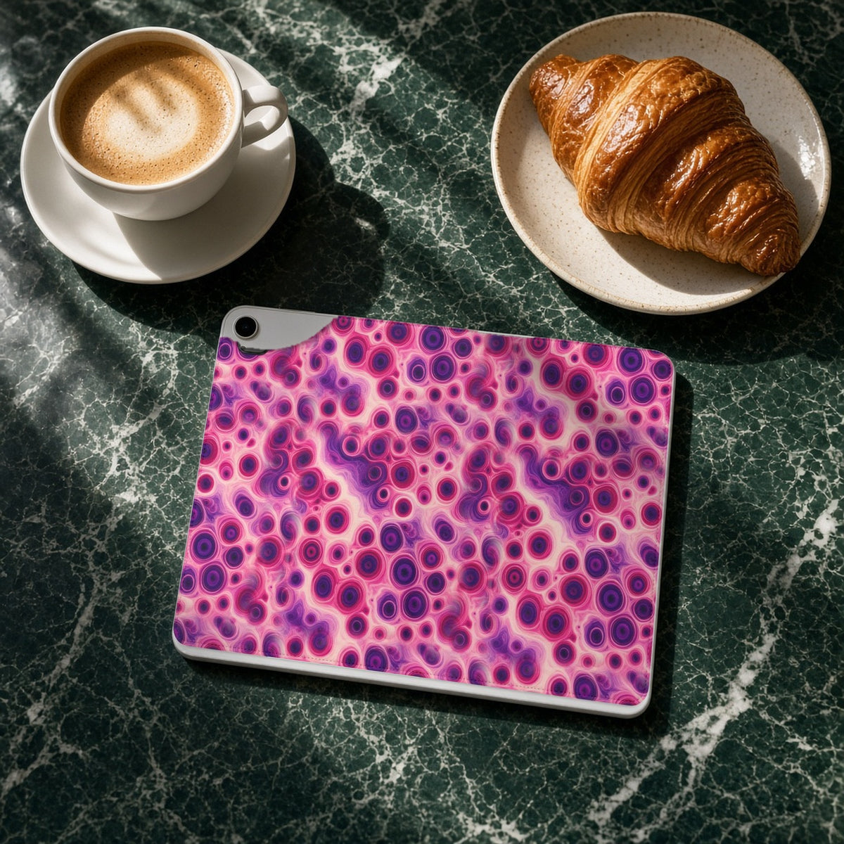 Berry Puddle Pour iPad folio case on a green marble cafe table with a cappuccino