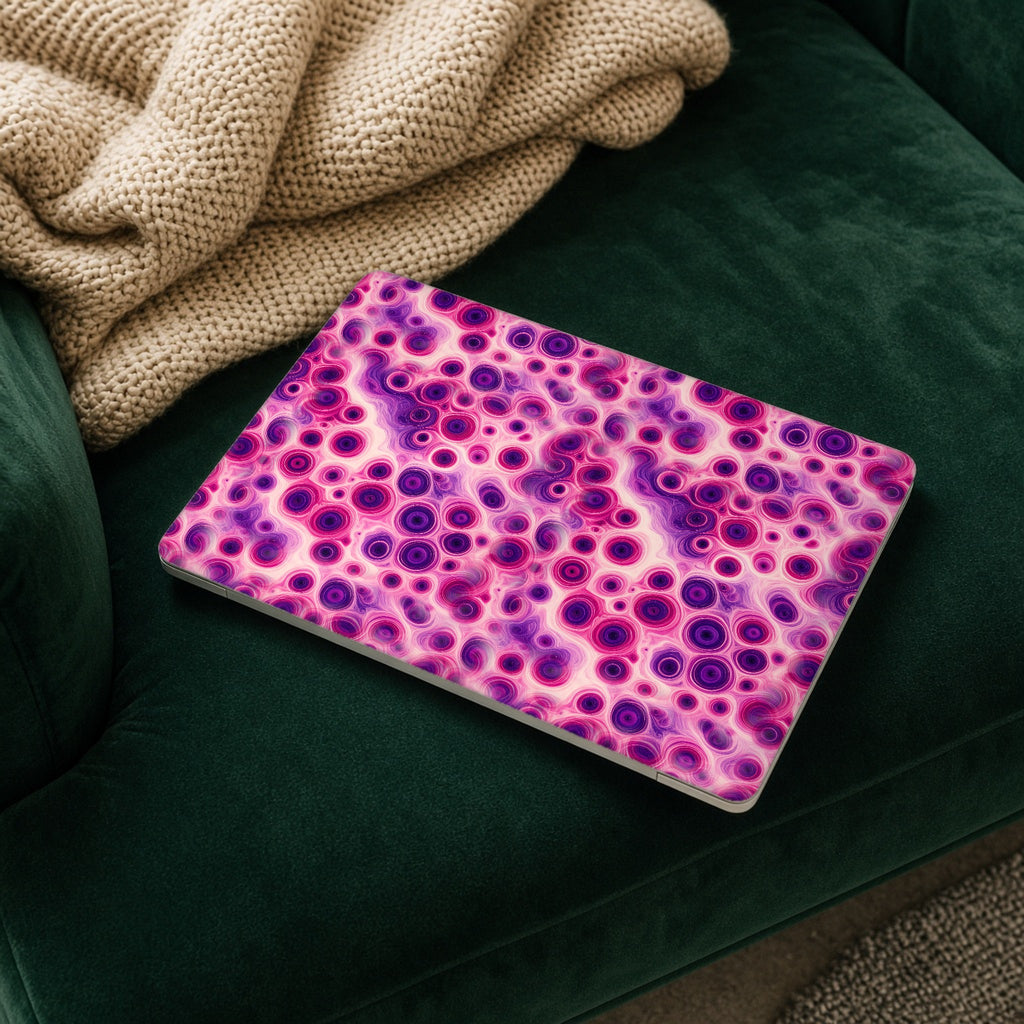 Berry Puddle Pour matte MacBook case on a laptop resting on a green velvet sofa