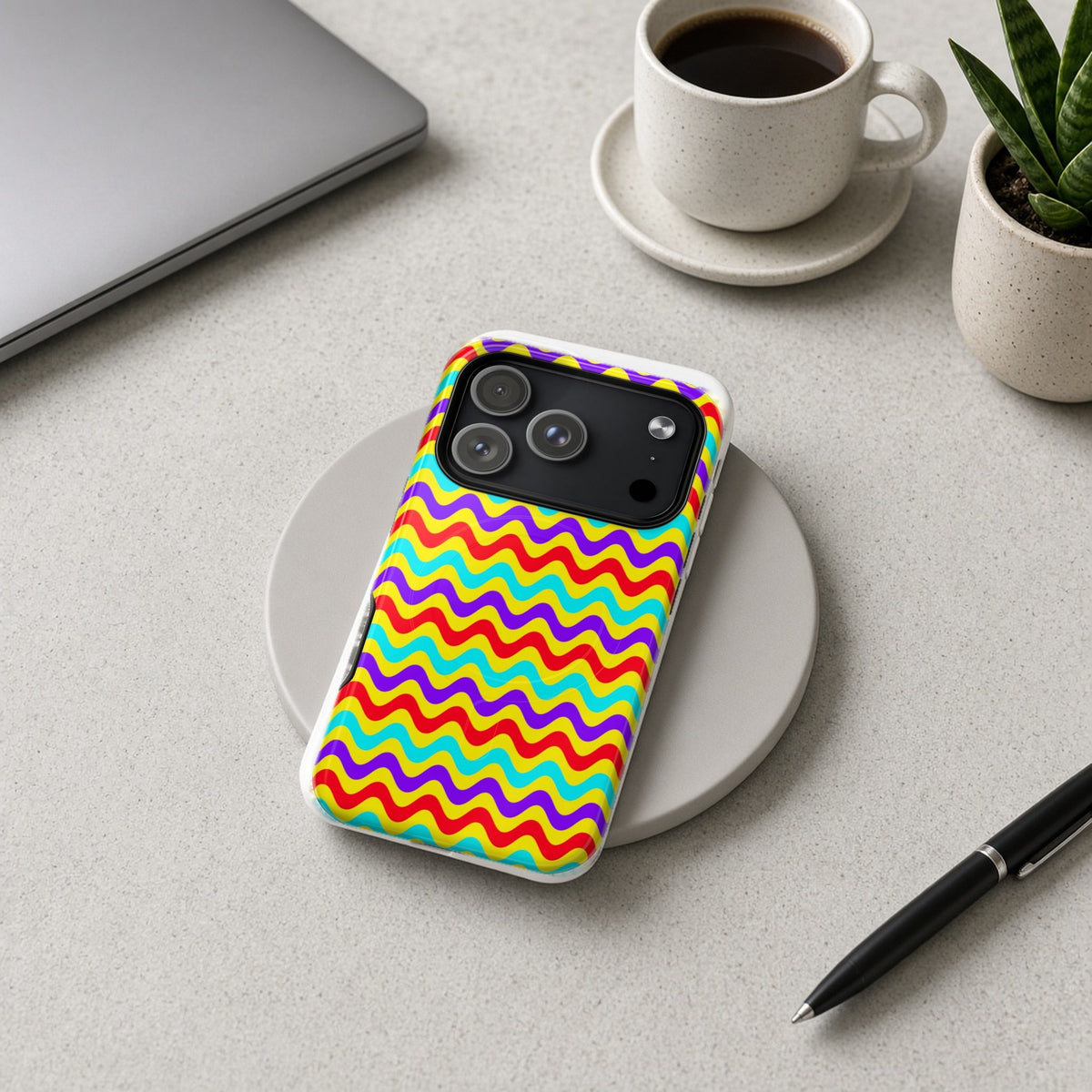 Big Ripple Chevrons magnetic iPhone case on a wireless charging pad on a grey desk