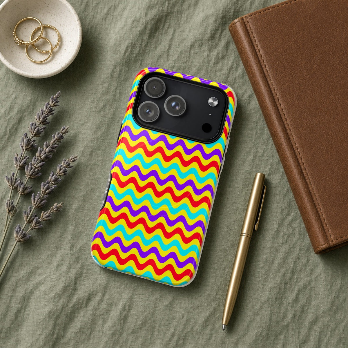 Big Ripple Chevrons magnetic iPhone case flat lay on sage linen with a notebook and pen