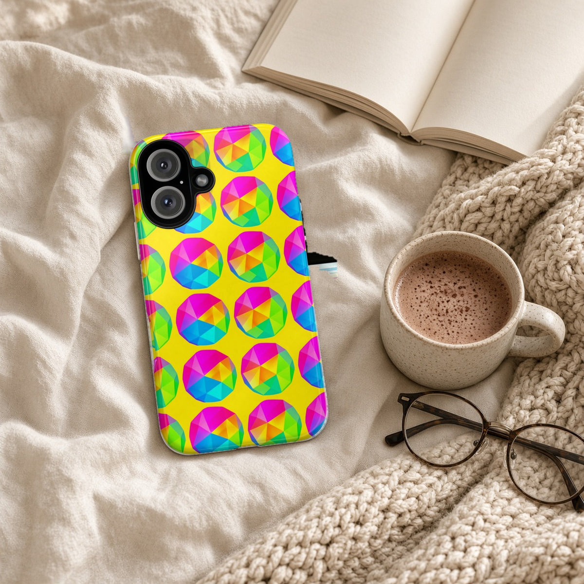 Holo Pebble Prisms tough phone case on a cosy knit blanket with a hot chocolate and glasses