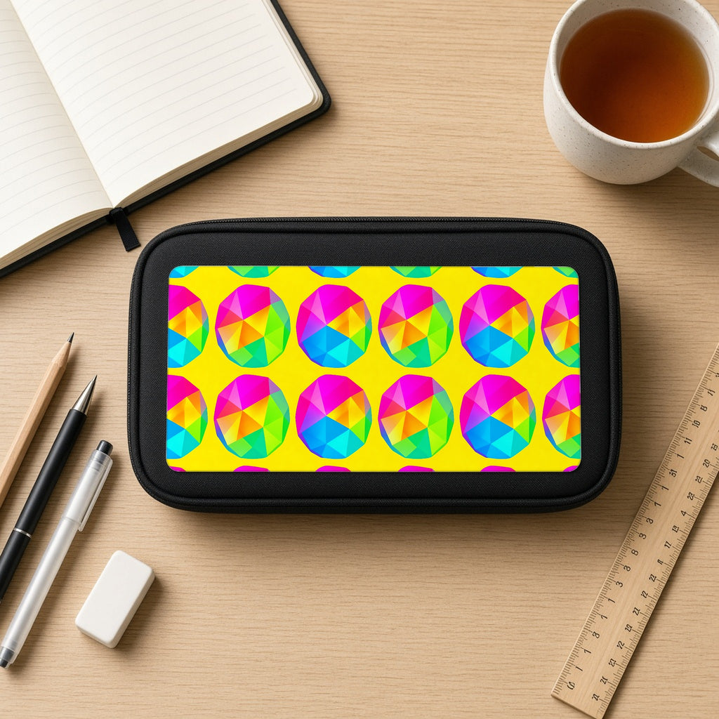Holo Pebble Prisms pencil case on a wooden desk with notebook, pens and a cup of tea