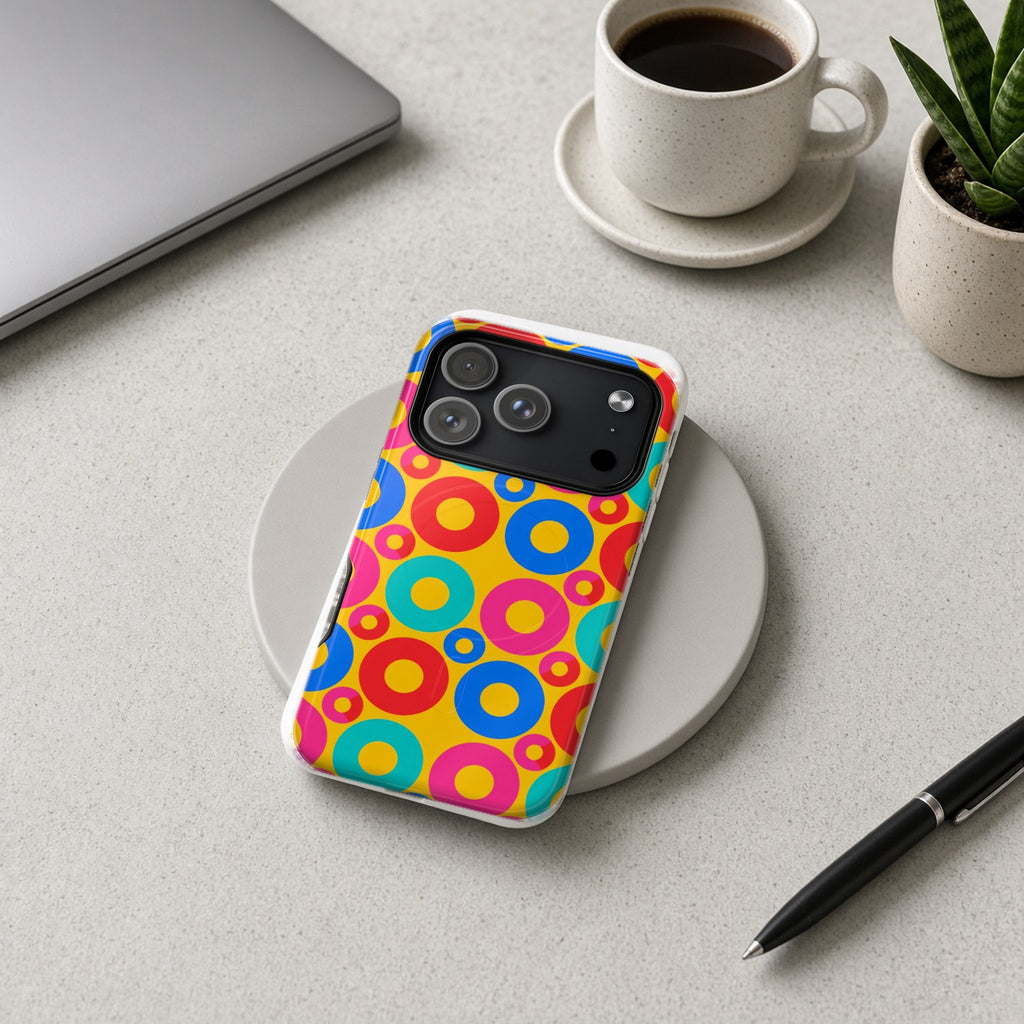 Big Ring Blocks magnetic iPhone case on a wireless charging pad on a grey desk