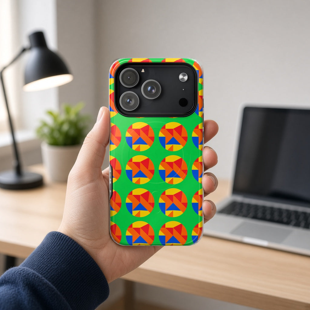 Hand holding the Broken Circle Planes magnetic iPhone case at a home office desk