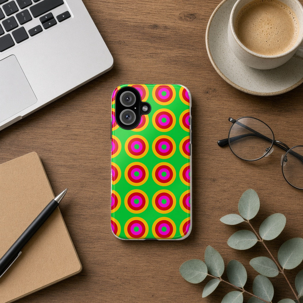 Giant Op-Art Jewel Rings tough phone case on a wooden desk beside a laptop, coffee and eucalyptus