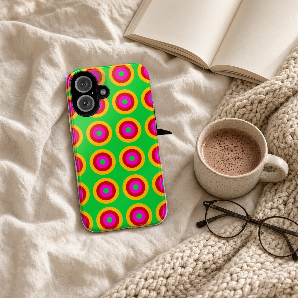 Giant Op-Art Jewel Rings tough phone case on a cosy knit blanket with a hot chocolate and glasses