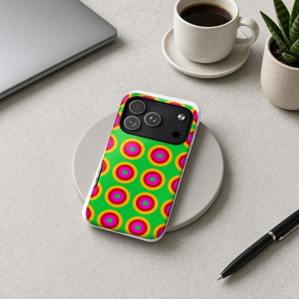 Giant Op-Art Jewel Rings magnetic iPhone case on a wireless charging pad on a grey desk