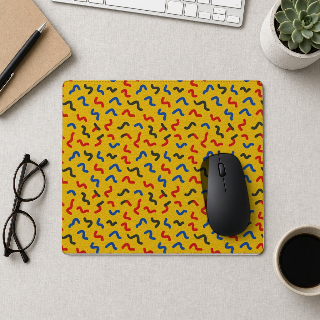 Squiggle Strokes Yellow vegan leather mouse mat from above with a mouse, notebook and glasses
