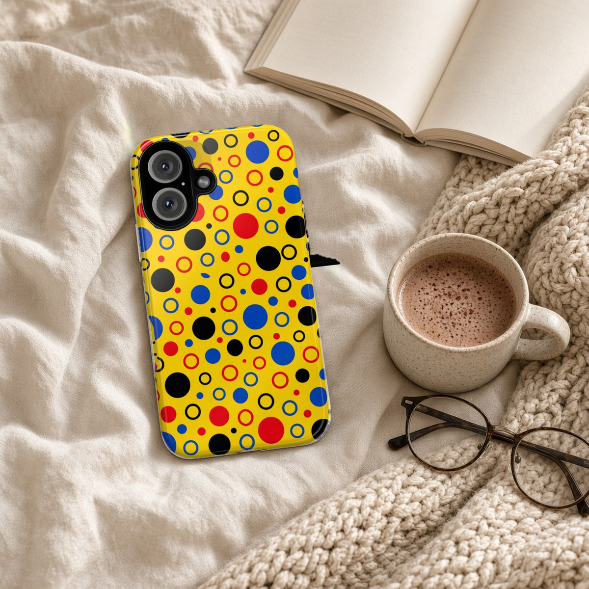 Bubble Outlines tough phone case on a cosy knit blanket with a hot chocolate and glasses