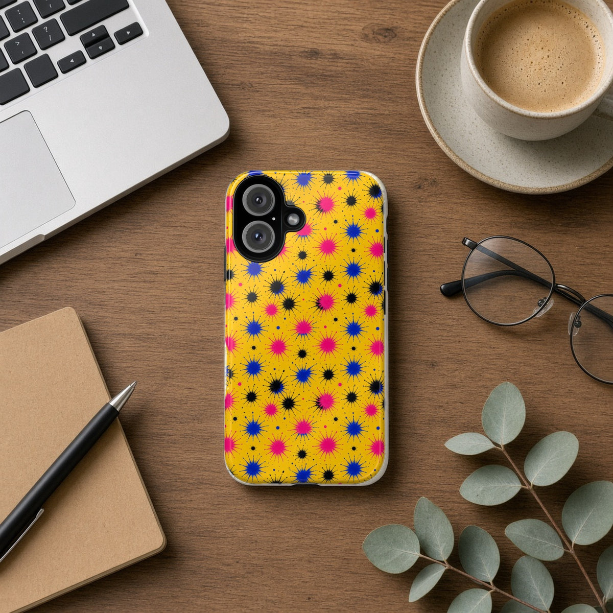 Splash Crowns tough phone case on a wooden desk beside a laptop, coffee and eucalyptus