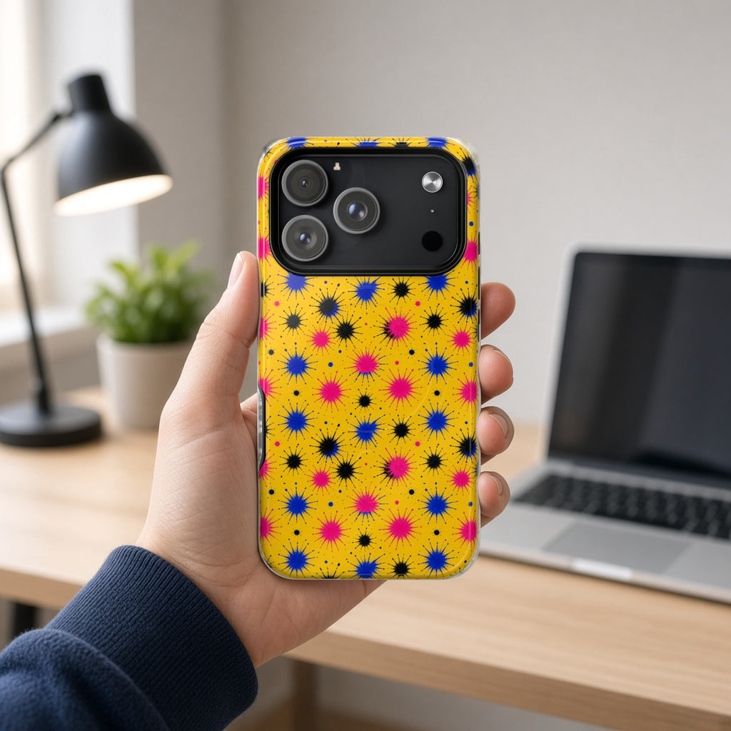 Hand holding the Splash Crowns magnetic iPhone case at a home office desk